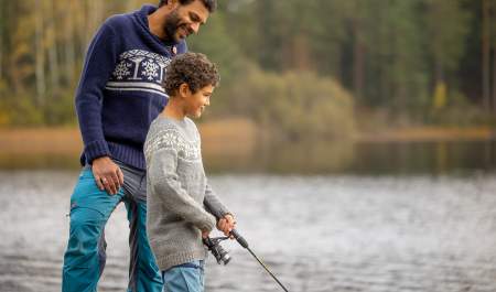 Mann og gutt som fisker ved et vann