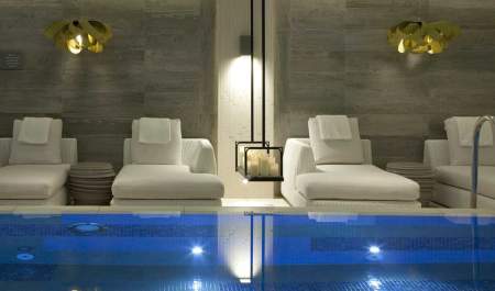 White luxurious loungers surround a tranquil indoor pool at The Dormy House in the Cotswolds