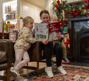 Family reading a book in Red Fern Booksellers at Holiday Open House 2025 in Salina Kansas