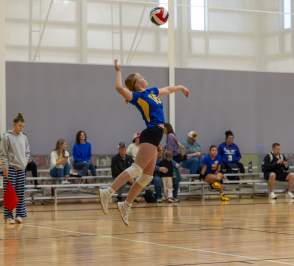 Female player spiking a volleyball at HOA Volleyball tournament. Located at the Salina Fieldhouse in Salina Kansas