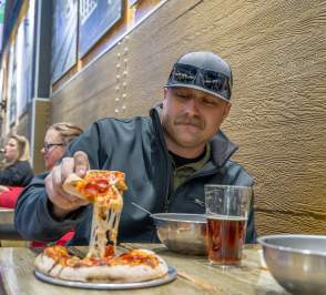 Guy eating pizza at Blue Skye Brewery and Eats in Salina, Kansas