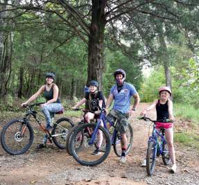 family on bikes in wooded trail