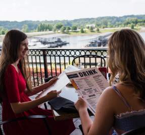 two ladies dining overlooking a marina