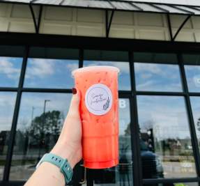 tea held in front of store front