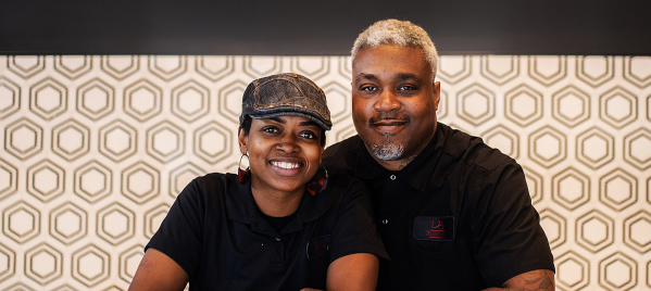 Delicious Bites Owners smiling behind treat counter