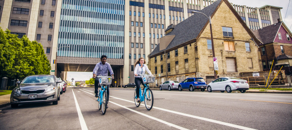 two people using bublr bikes, biking under the clocktower