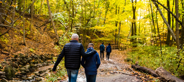 family walking on trail with fall colors surrounding