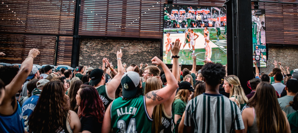 crowd of people watching and cheering on bucks in a beer garden