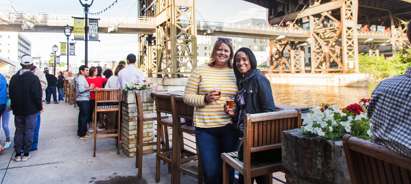 two friends smiling on riverwalk by Lakefront Brewery