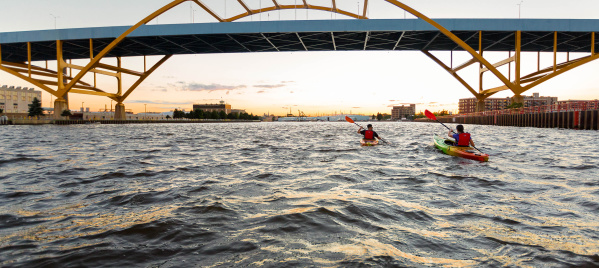 two kayakers kayaking under the Hoan Bridge