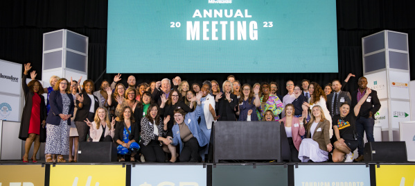 the visit milwaukee team smiling and cheering at the 2023 annual meeting