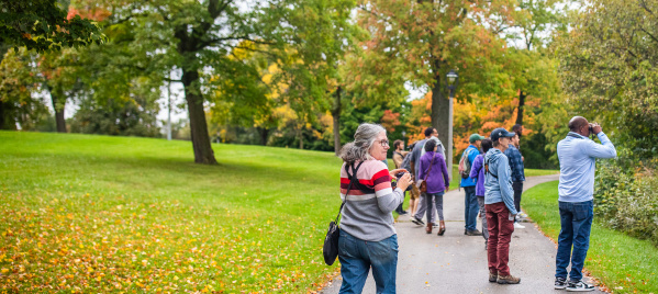 a woman with binoculars birding in a park
