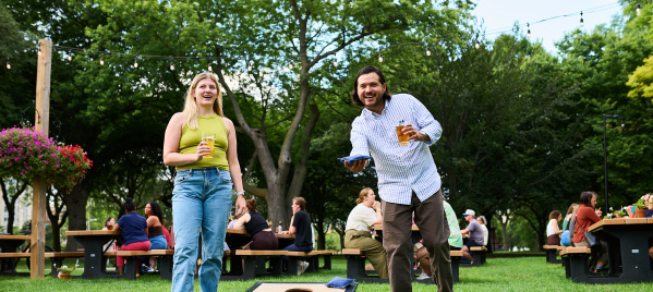 A man and woman playing bags at Juneau Beer Garden