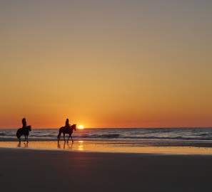 Horseback riding on the beach at sunset in the Golden Isles