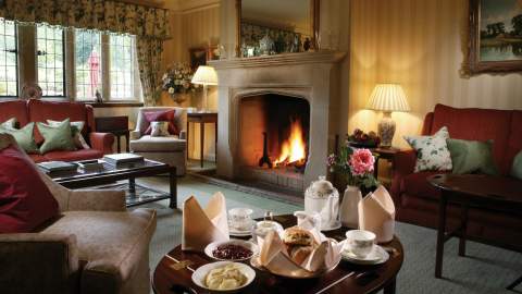 Afternoon tea served in a cosy lounge with open log fire at Buckland Manor
