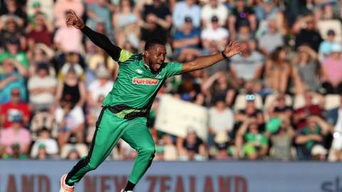 Cricket player jumping for joy on field of The Hundred match