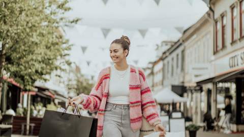 Kvinne på handleposer i hver hånd i gågata i Sarpsborg. Foto.