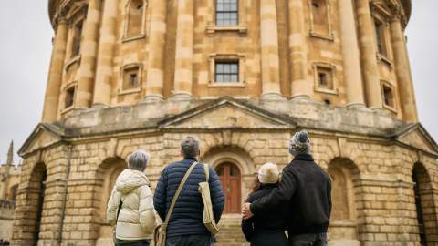 A group of people look at the outside of the historic Bodleian Library in Oxford