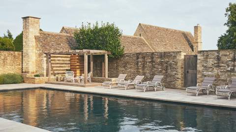 Sunlight glints on the outdoor courtyard pool at The Meadow Spa at Thyme in the Cotswolds