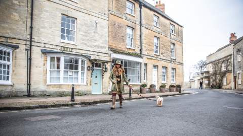 Woman wrapped up warmly taking her dog for a walk in Woodstock