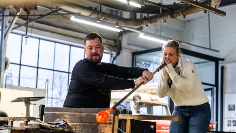 Kvinne blåser glass hos Hadeland Glassverk