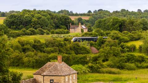 A view of North Leigh Roman Villa with a GWR train passing in the distance behind
