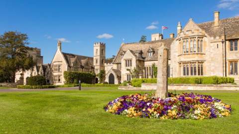 A bed of purple and yellow flowers in front of the stunning facade of Ellenborough Park