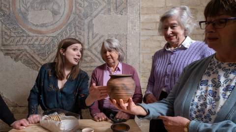 An expert tour guide talks to a group about artefacts at the Corinium Museum