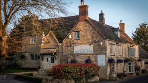 Evening sun lights up the Cotswold stone brickwork of The Red Lion Long Compton in the Cotswolds