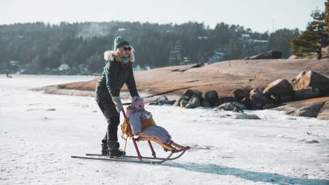En kvinne og et lite barn som står på spark på Tunevannet i Sarpsborg. Foto.