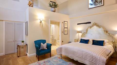 A vaulted ceiling bedroom with an ornate king-sized bed