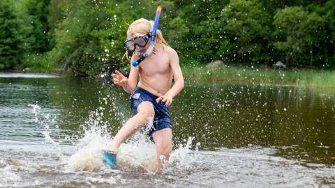 Gutt med dykkemaske som bader