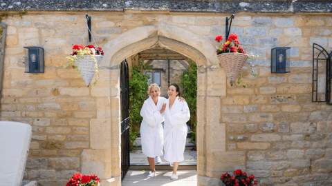 Ladies coming out of spa at Ellenborough Park hotel wearing white robes.