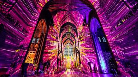 Purple and yellow light fills the interior of Tewkesbury Cathedral in the Cotswolds