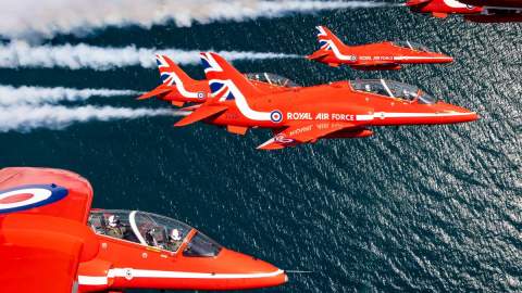 5 Red Arrows flying above open water