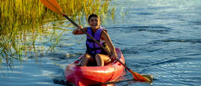 a woman kayaking in the marsh