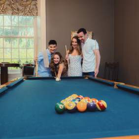 Friends playing pool at a bed and breakfast.