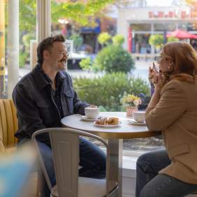 Couple chatting in a cafe window seat