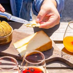 Hand spreading cheese on a cracker.