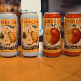 Four cans of cider sitting on a countertop