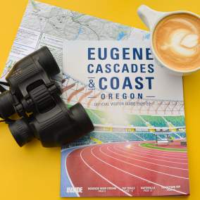 Eugene cover visitor guide with binoculars and coffee