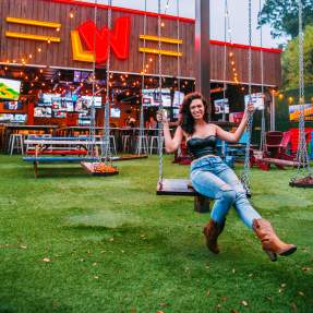 Woman swinging at Little Woodrow's in Beaumont, TX