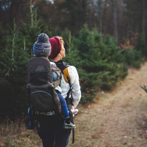 Woman hiking with toddler on her back in a carrier