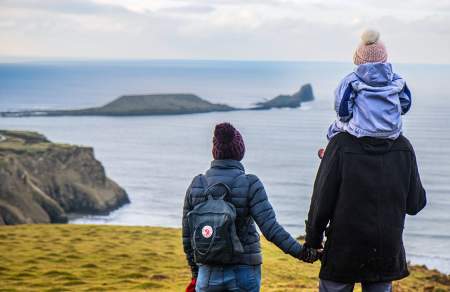 A man and a woman looking out at Worm's head. The man has a child on his shoulder.