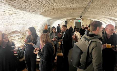 Groups of people stand talking in the Vaulted Cellar at Kings Head Hotel in Cirencester
