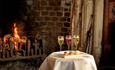 A table with drinks and canapes in front of a fire at Ellenborough Park