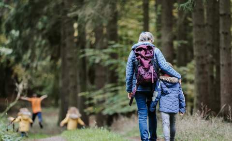 Familie som går tur i skogen