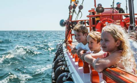 Three children looking out to sea aboard a pirate ship ride in East Yorkshire