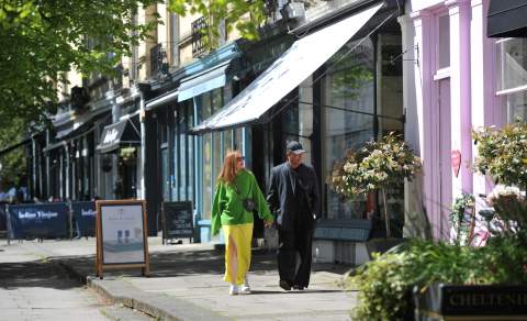 Shoppers in Montpellier District Cheltenham, walking past row of shops.