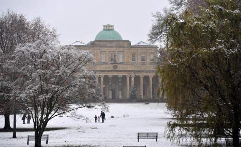 Visitors walking through a snow filled park in Cheltenham, Pittville Park in the snow